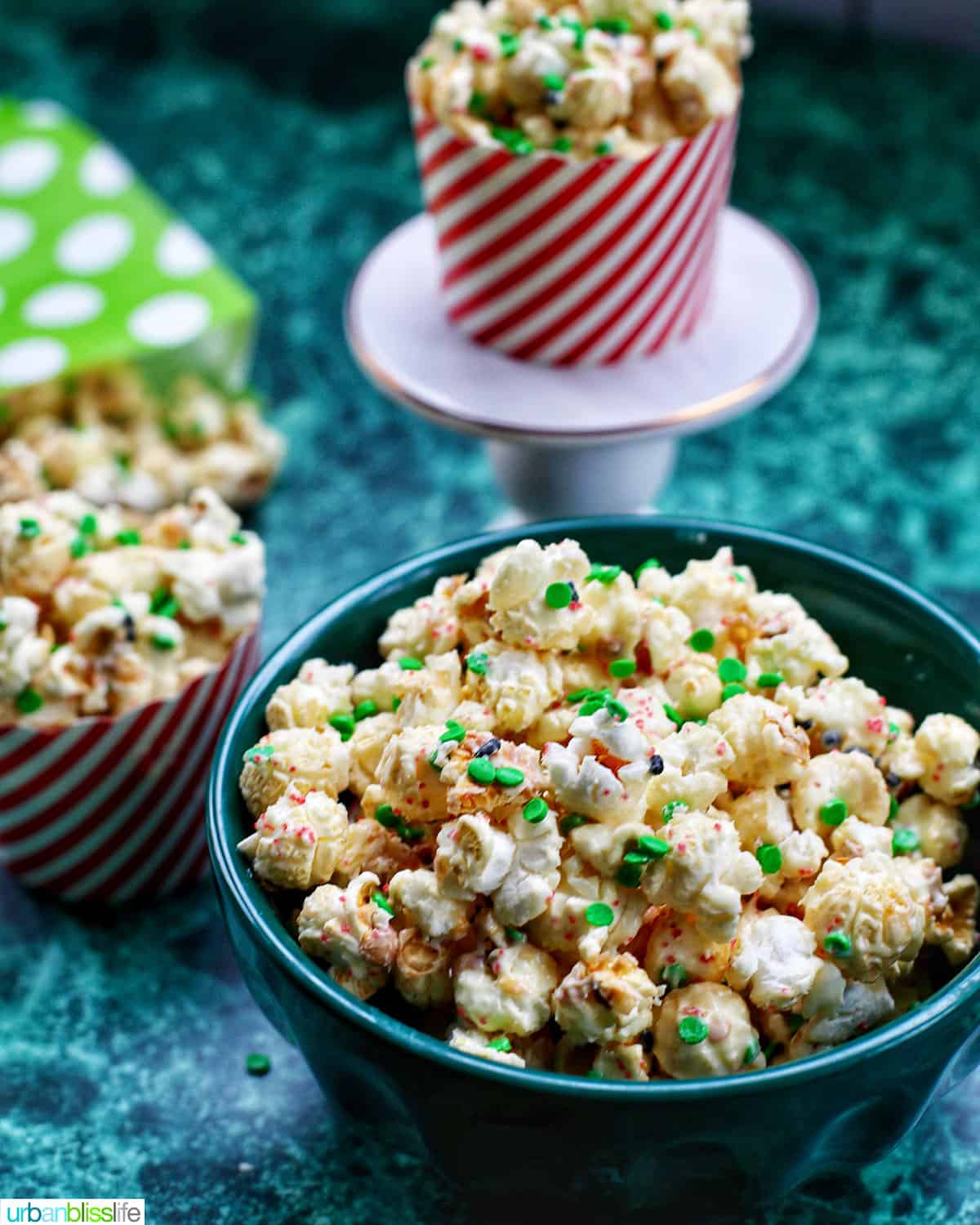 Christmas popcorn in bags and popcorn holders on a green table.