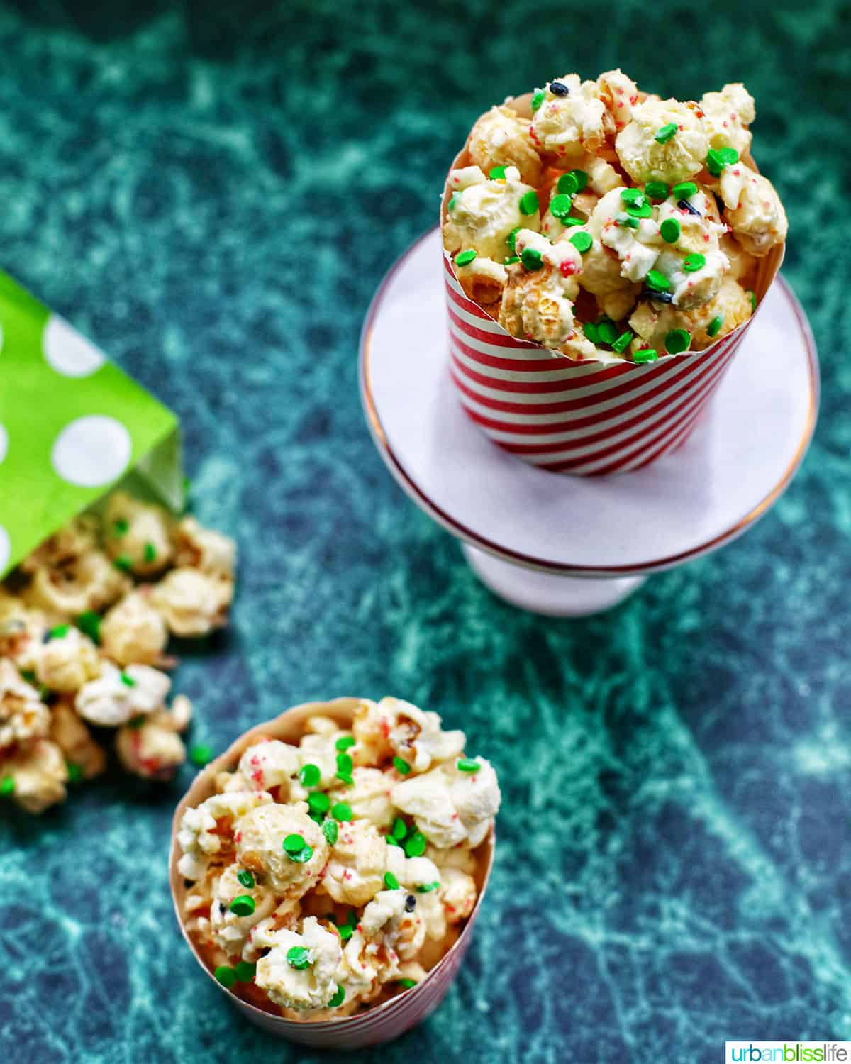 Christmas popcorn in bags and popcorn holders on a green table.