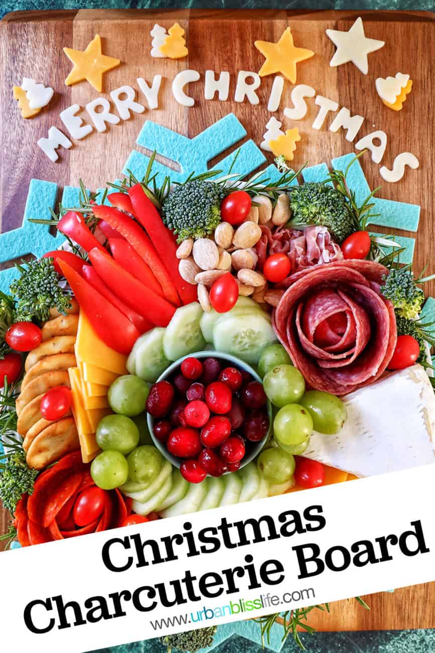 Christmas charcuterie board with variety of meat, cheeses, fruits, vegetables, and nuts.
