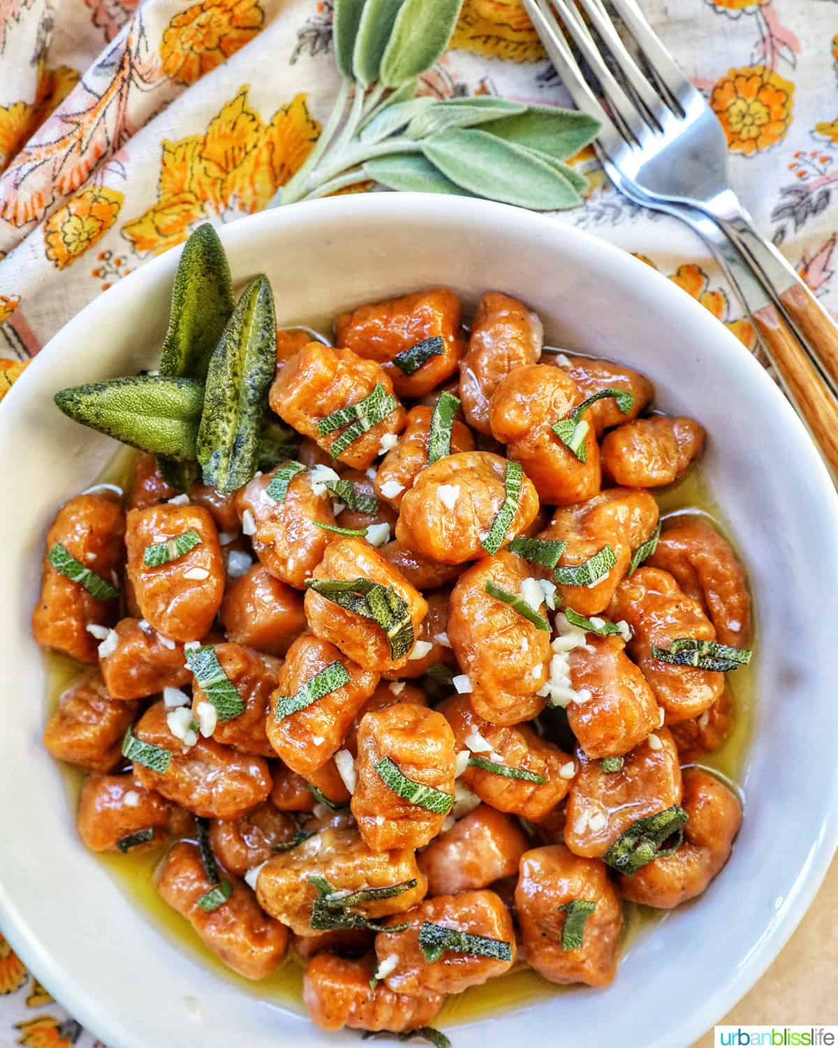 bowl of pumpkin gnocchi with a fork and colorful napkin.