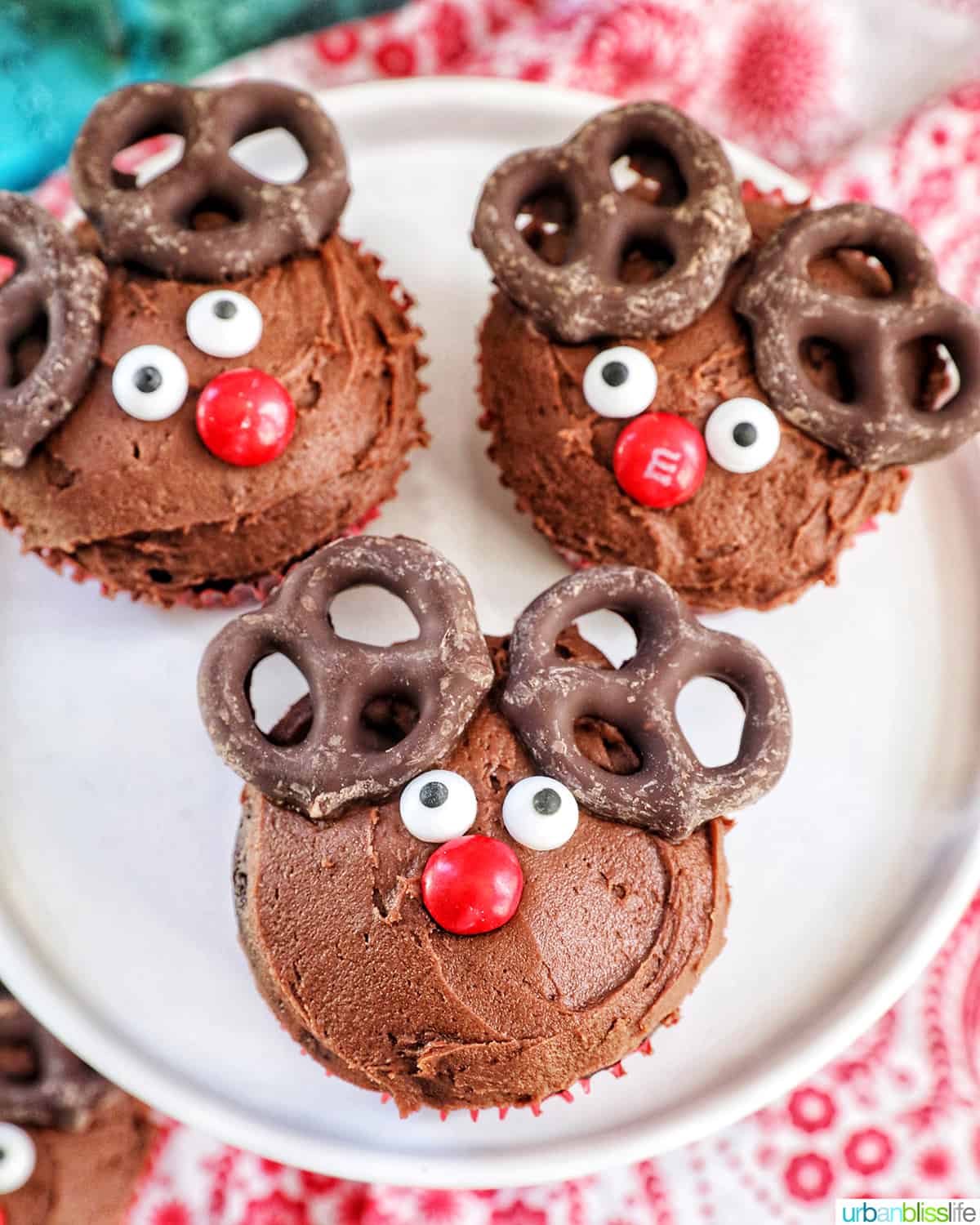 three reindeer cupcakes on a plate.