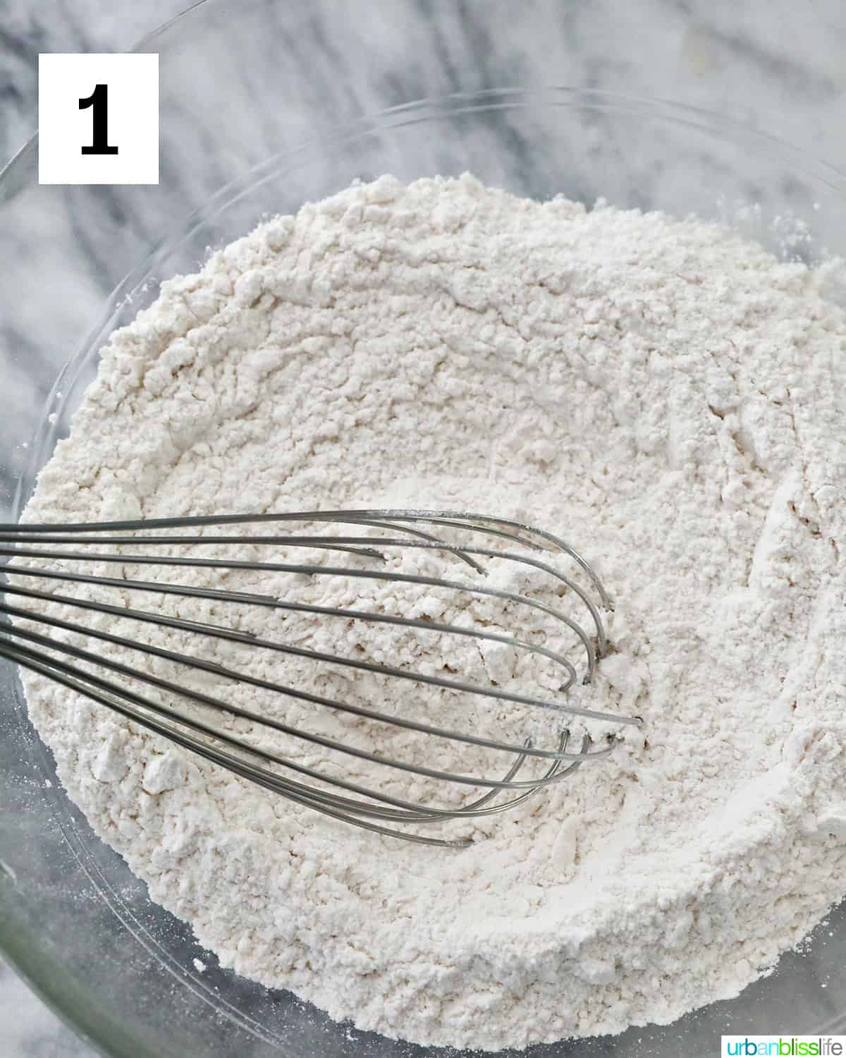 whisking flour and other dry ingredients in a mixing bowl.