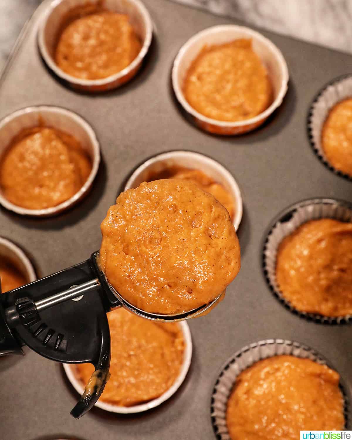 scoop of pumpkin banana muffin batter to be put into the muffin cups.