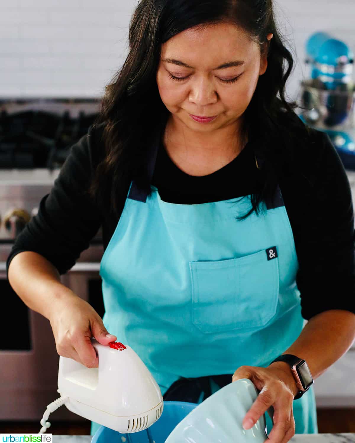 Marlynn in an aqua HB apron baking.