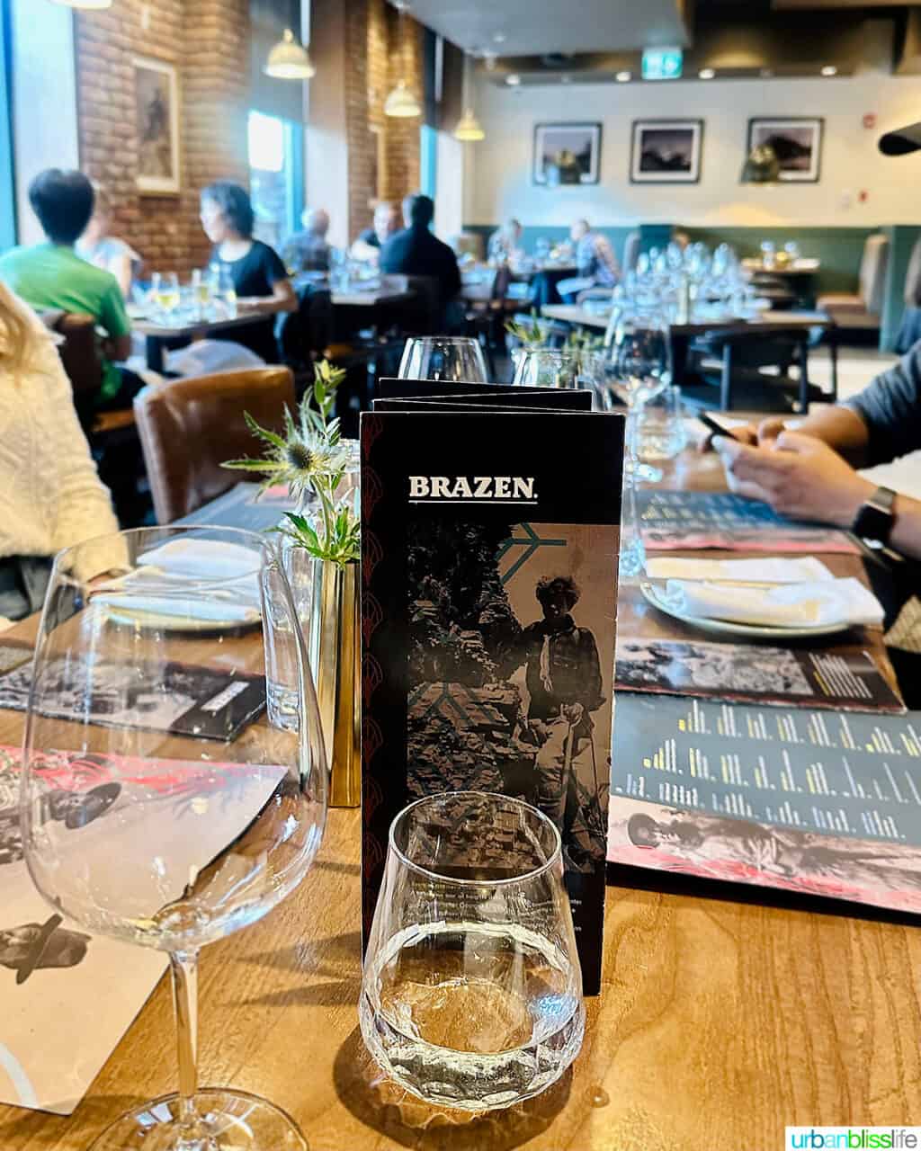 table and interior photo of Brazen Banff restaurant with menu in foreground.