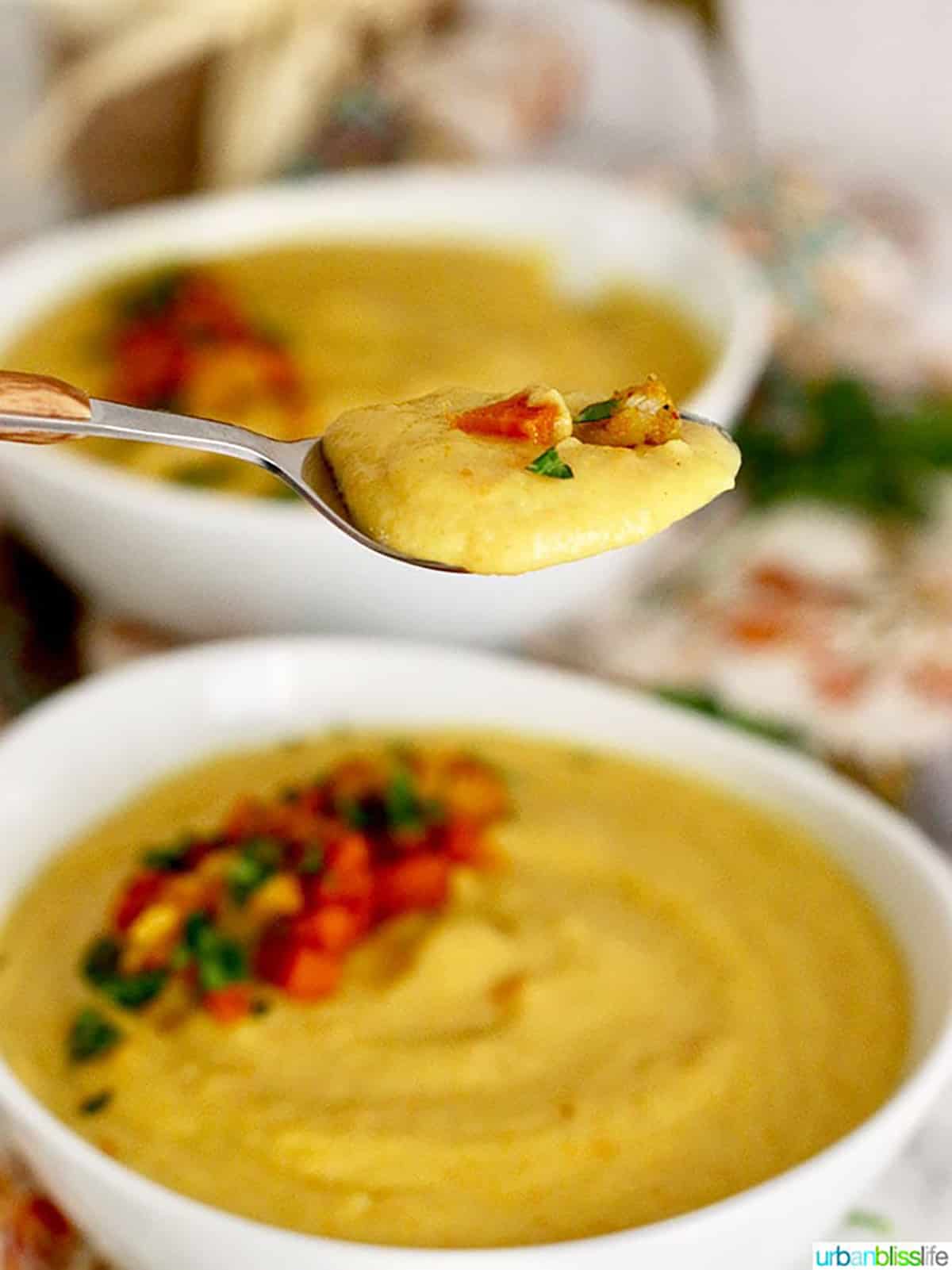 spoonful of Vegan Cauliflower Soup above a bowl of soup.