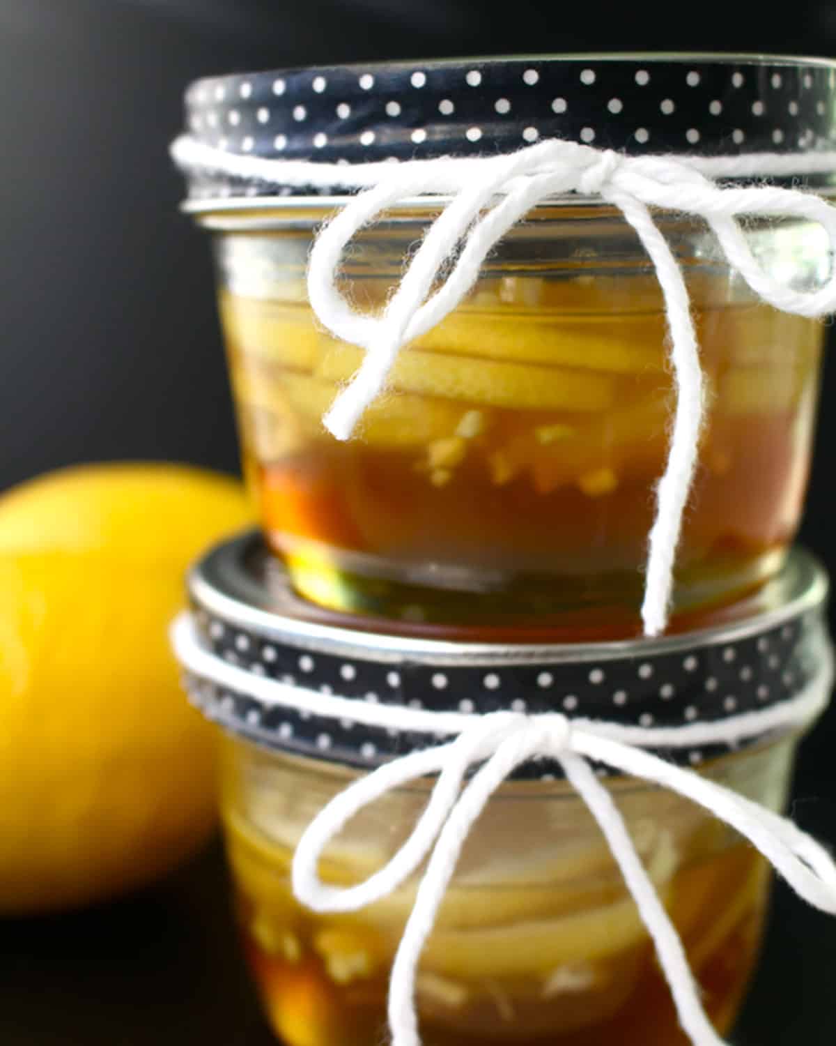 ginger lemon honey syrup in two stacked mason jars