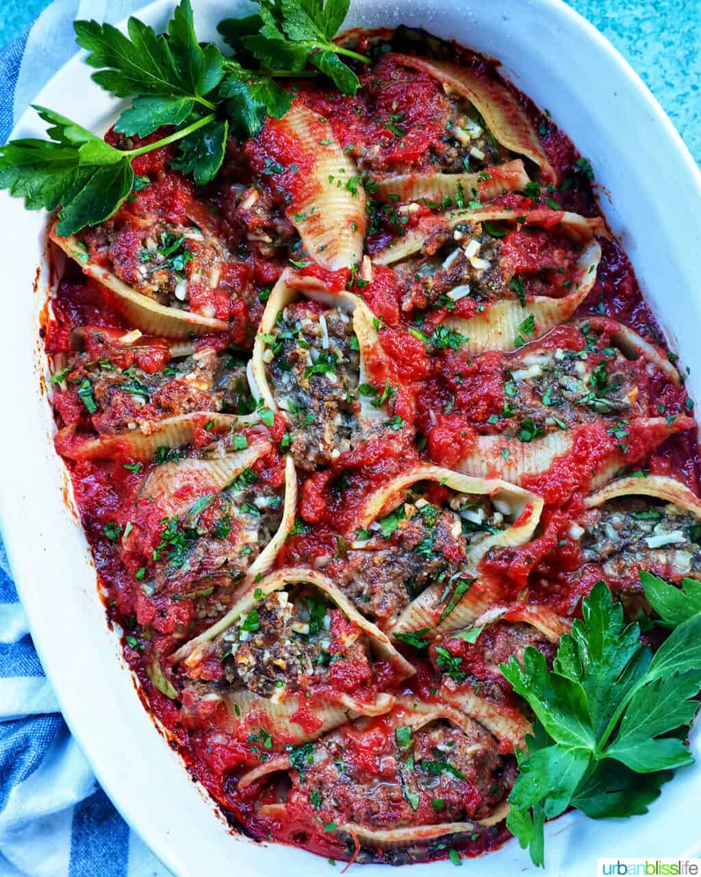 A casserole dish full of stuffed shells with ground beef.