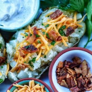 Loaded air fryer baked potato with title text overlay and sides of sour cream, cheddar cheese, parsley, and bacon.