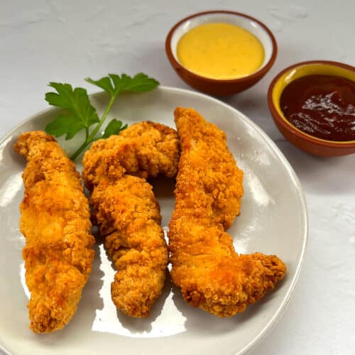 air fryer frozen chicken tenders on plate with bbq and honey mustard sauce