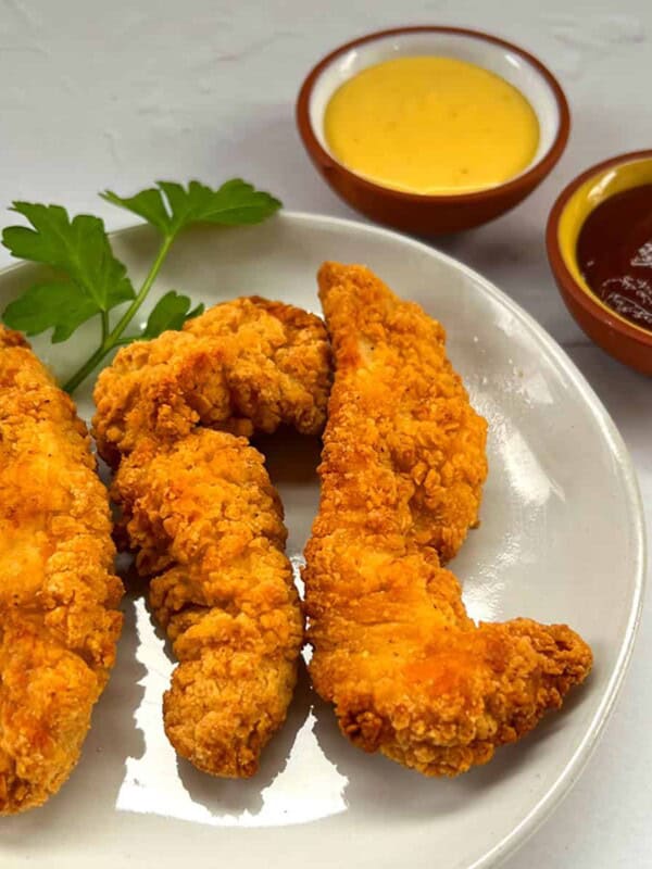 air fryer frozen chicken tenders on plate with bbq and honey mustard sauce