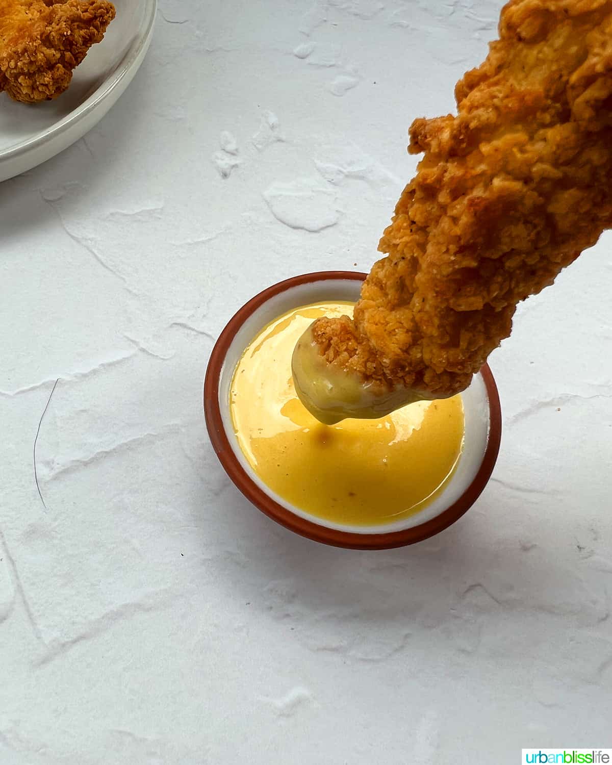 air fryer frozen chicken tenders dipping in honey mustard sauce
