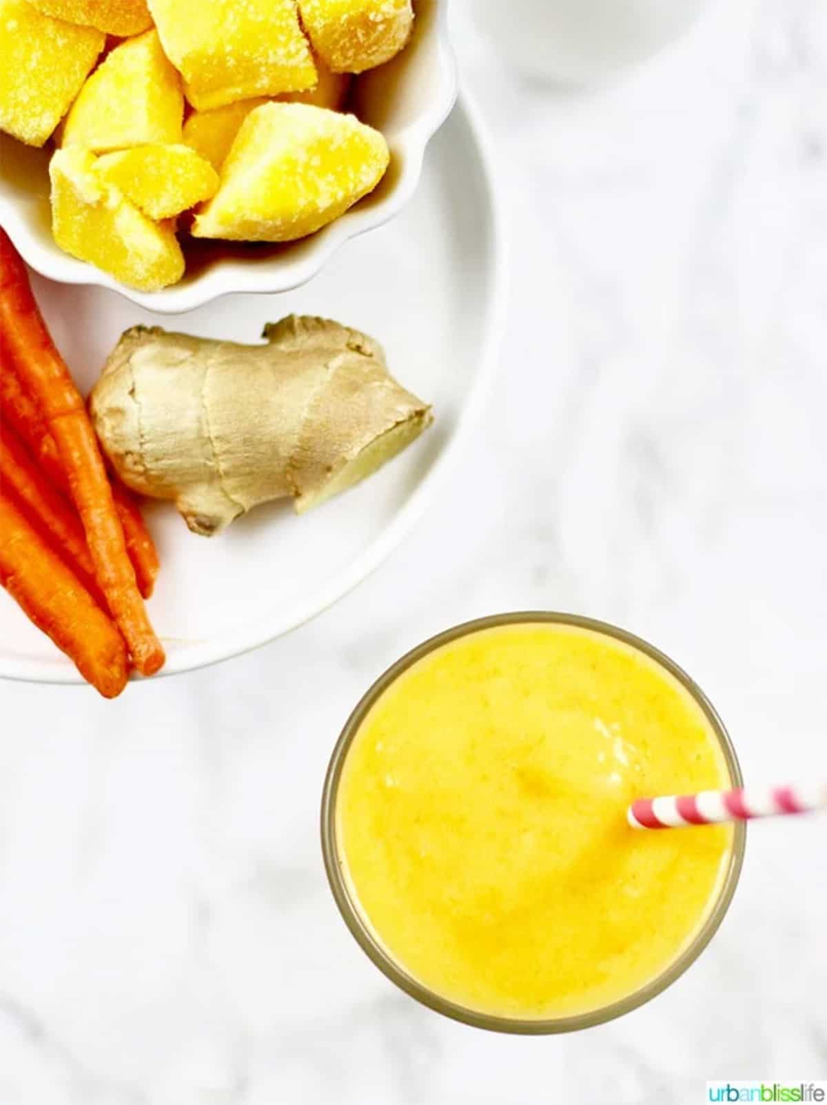 mango carrot smoothie with ginger and carrot in background