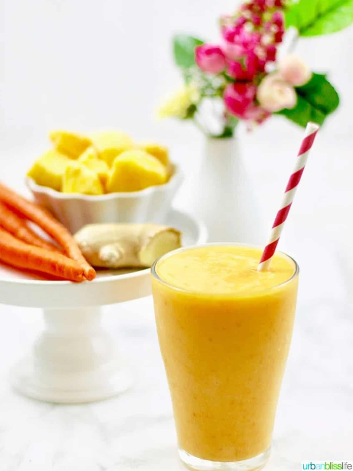 mango carrot smoothie in glass with straw