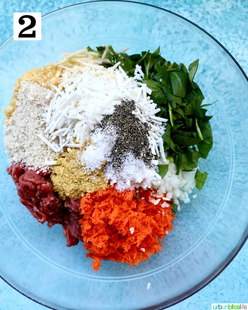 bowl of ground beef, carrots, spinach, dairy free cheese, herbs and spices to make the filling for stuffed shells with ground beef.
