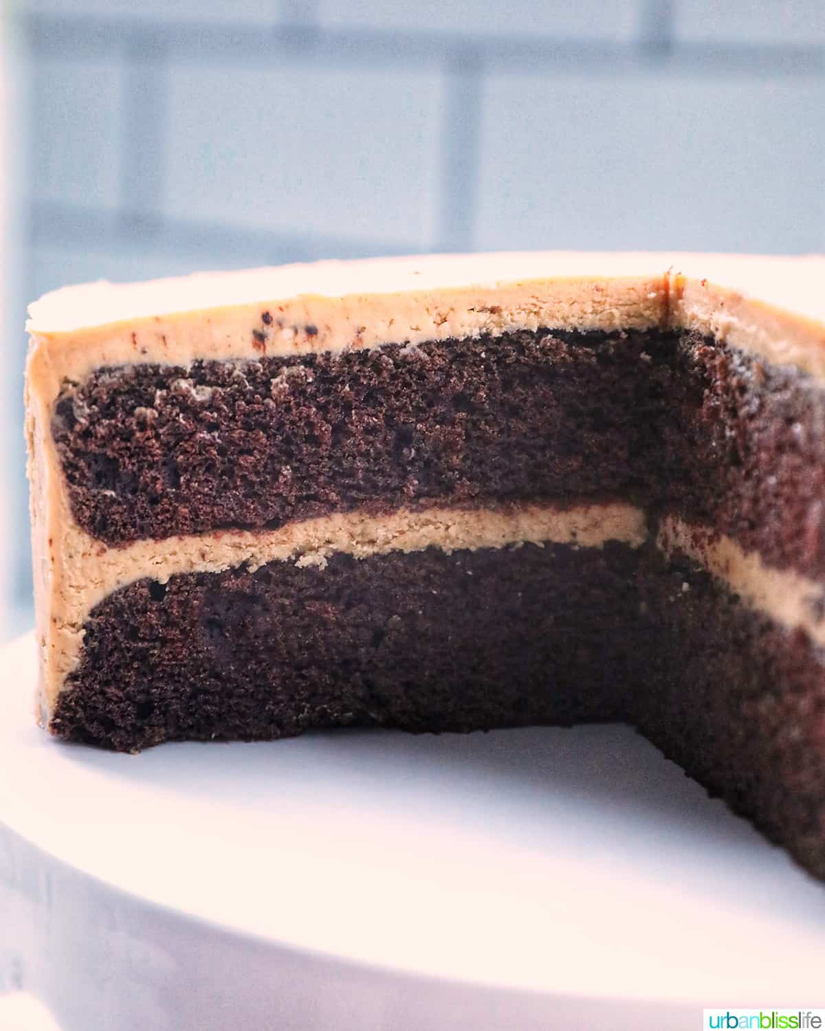 chocolate coffee cake on a white cake pedestal sliced open to show the cake layers.