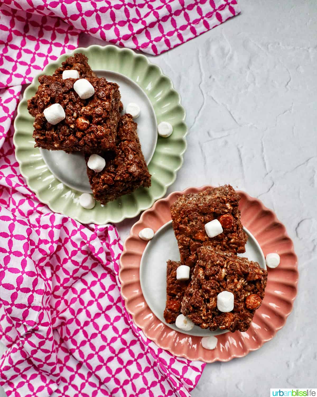 chocolate rice krispies treats stacked with marshmallows on two plates