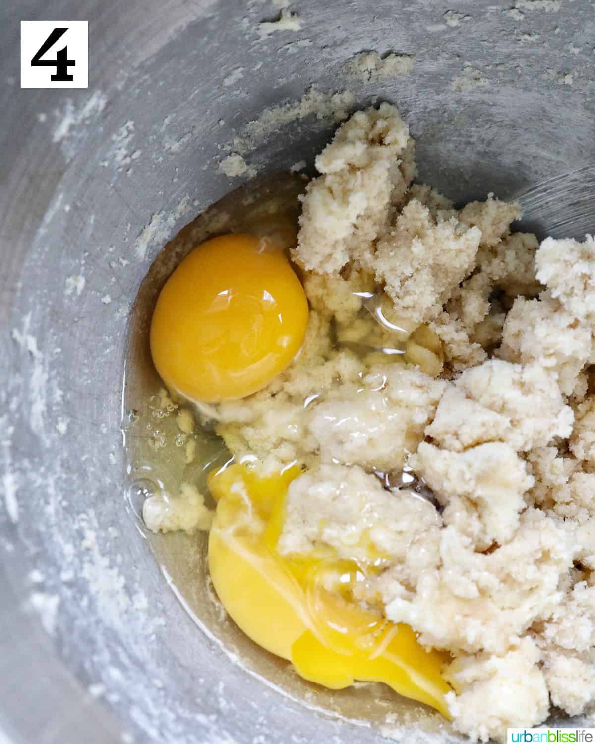 eggs added to a stand mixer bowl with dough.
