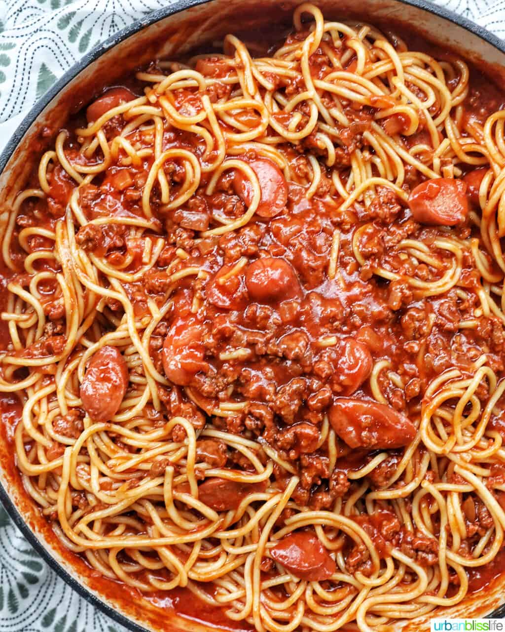 large pan of Filipino style spaghetti with hot dogs and ground beef.