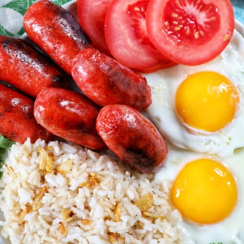 longanisa sausage, sliced tomatoes, fried eggs, and garlic rice known as Filipino Longsilog.
