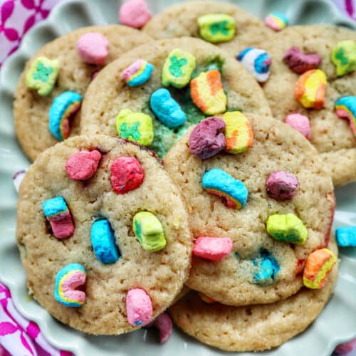 plate full of Lucky Charms Cookies on top of one another at angles with bright colorful marshmallows.