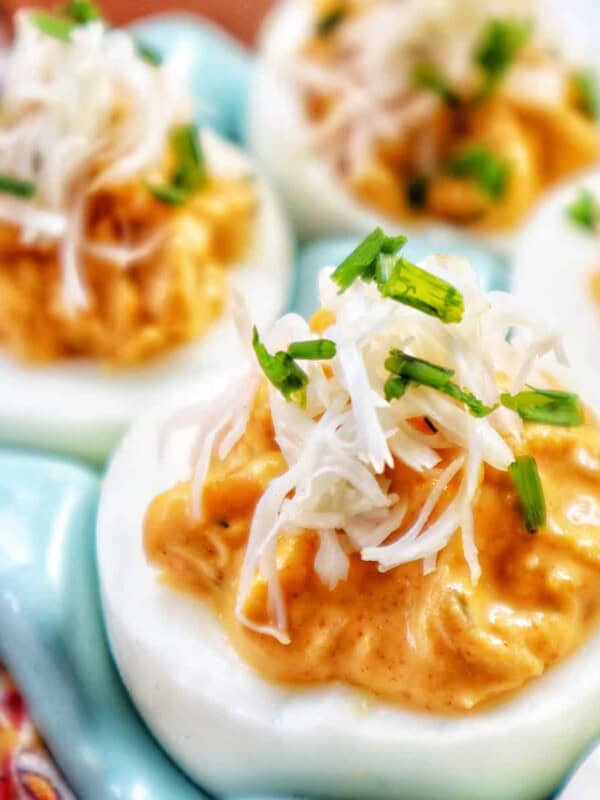 closeup of crab deviled eggs in a blue egg holder.