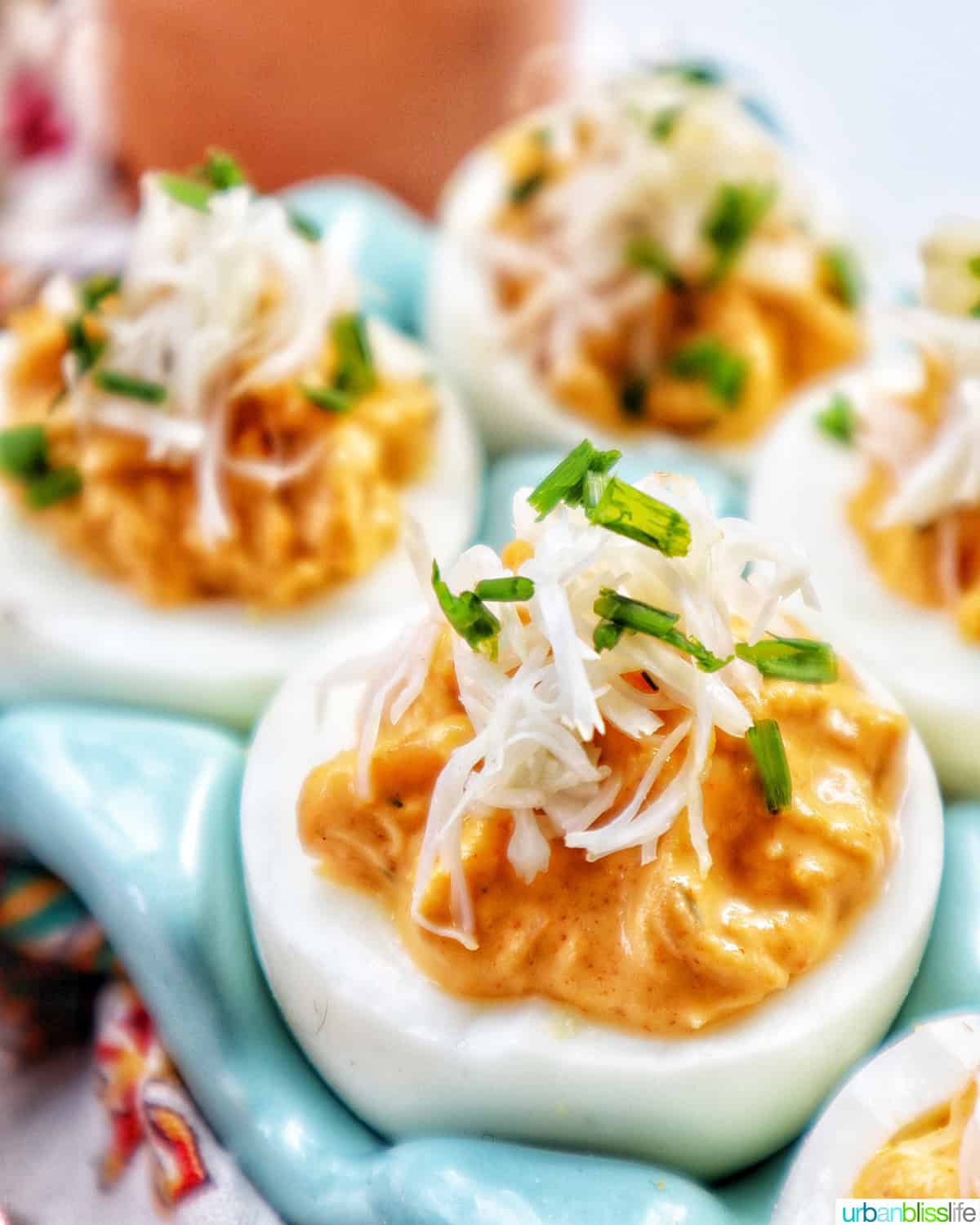 closeup of deviled eggs with crab meat and chives on top.