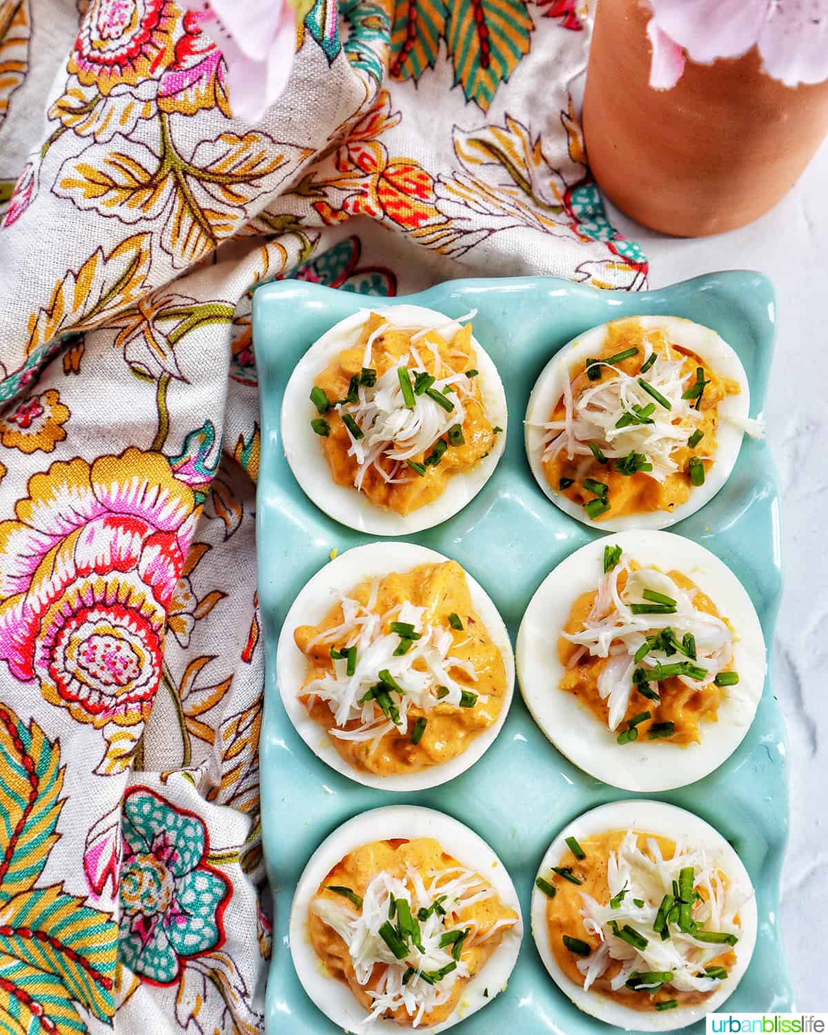 six crab deviled eggs in a blue egg holder.