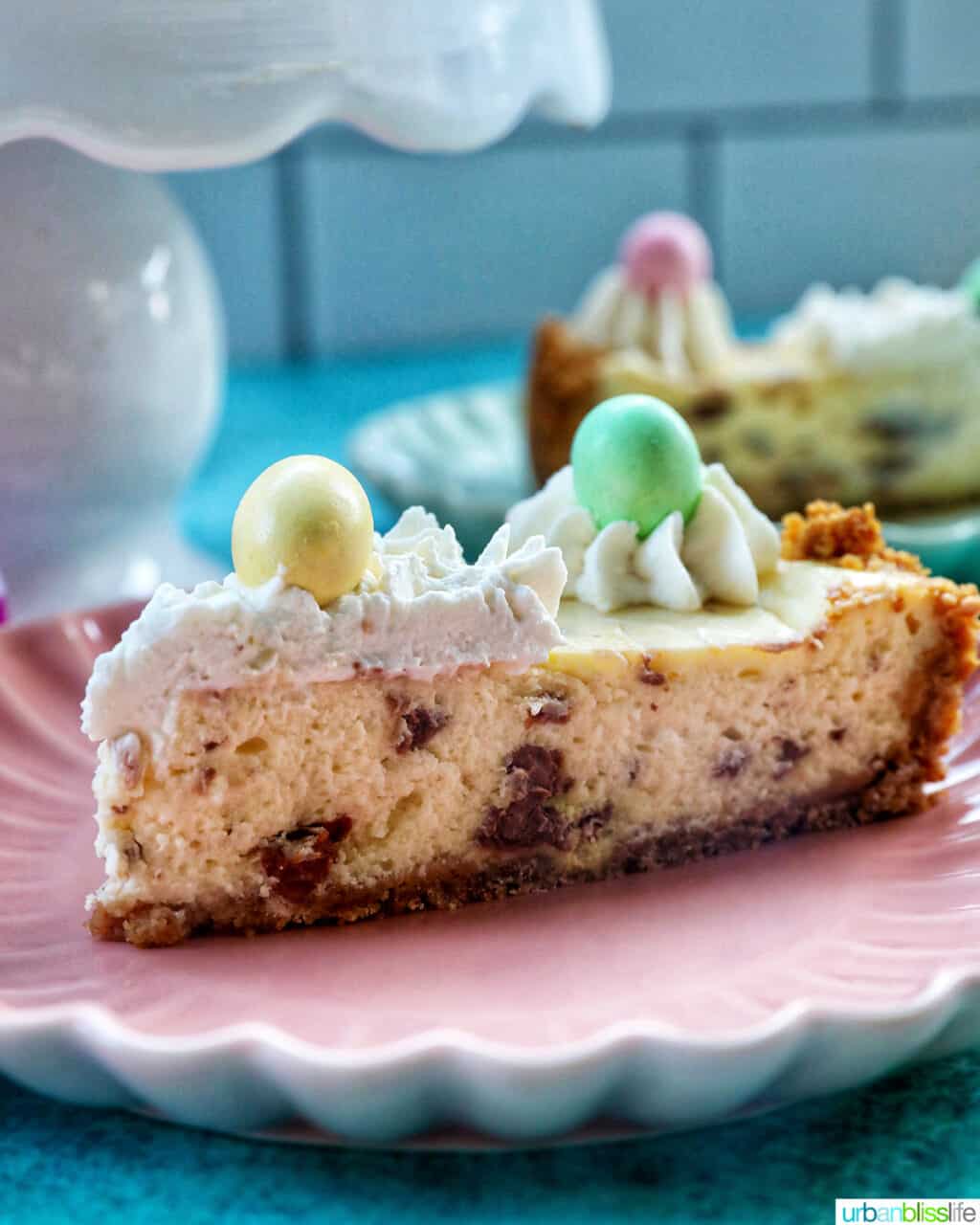 slice of easter egg cheesecake on a pink plate.
