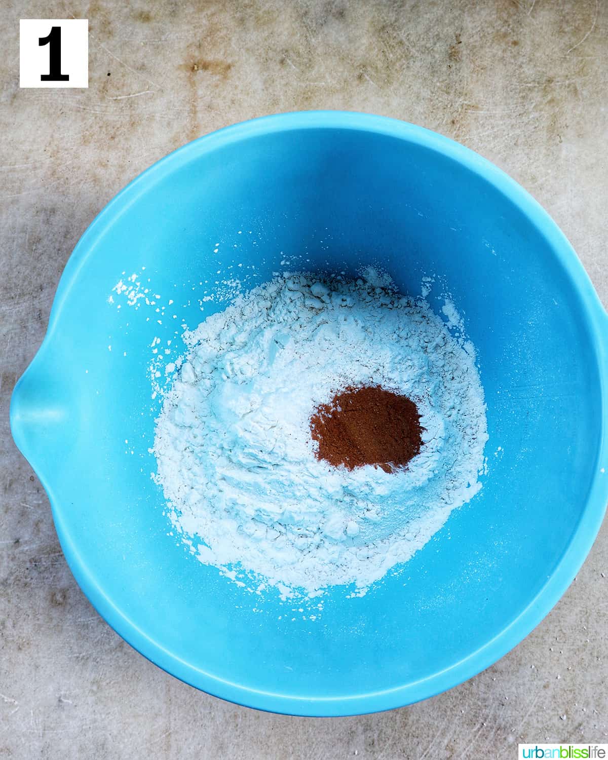 blue bowl with flour, salt, baking powder, cinnamon to make cupcakes.