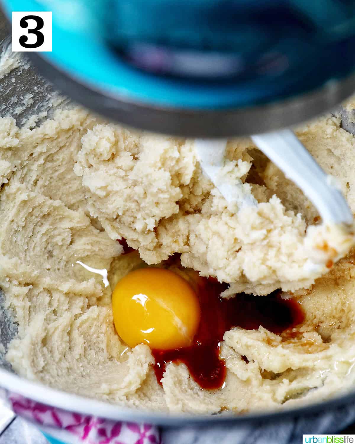 adding egg and vanilla to the creamed butter in a stand mixer.