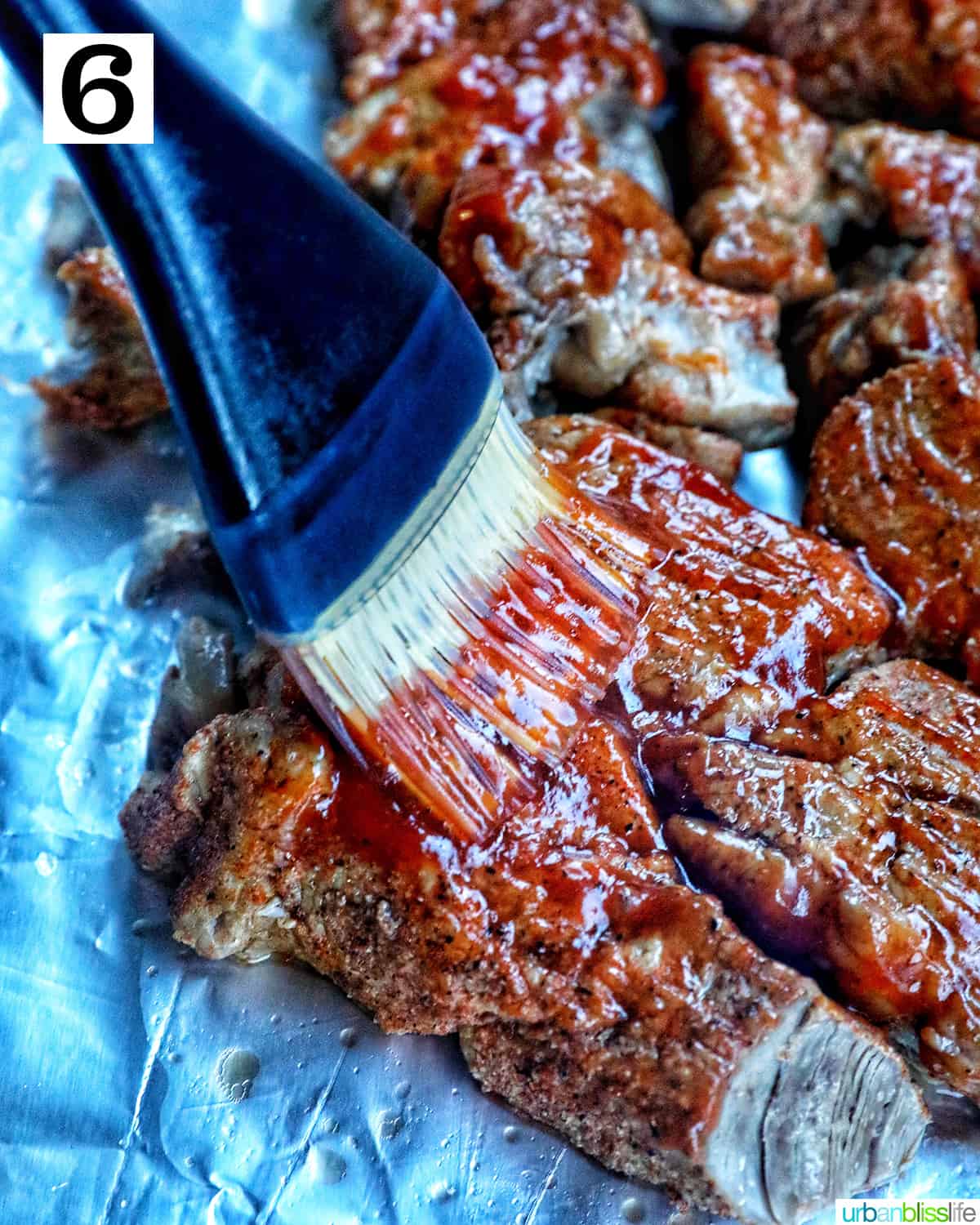 pastry brush basting ribs with bbq sauce.