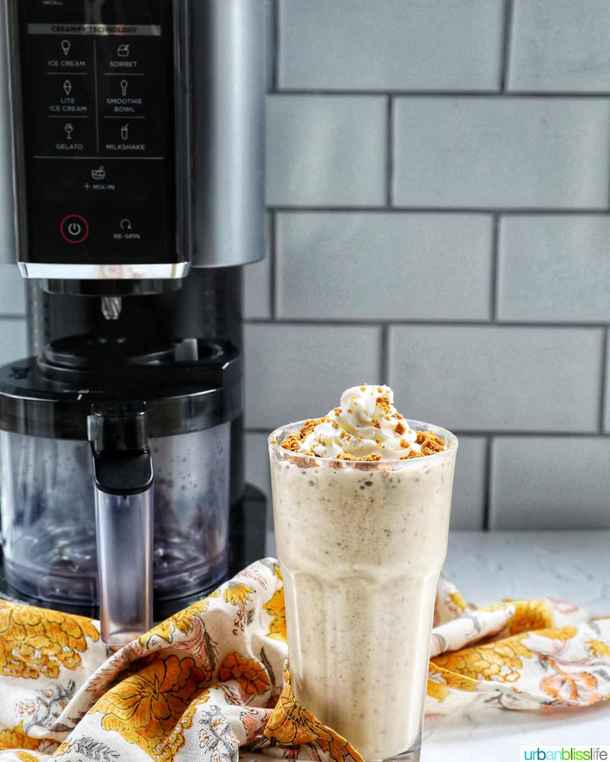 Biscoff milkshake in front of a Ninja Creami machine.