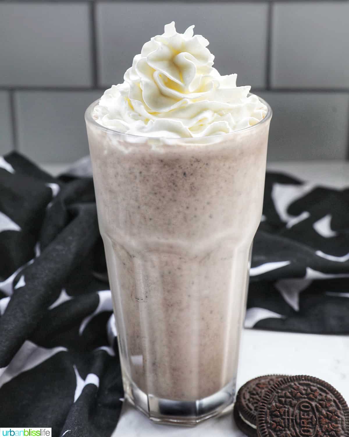 Cookies & Cream Milkshake in a tall glass with whipped cream topping.