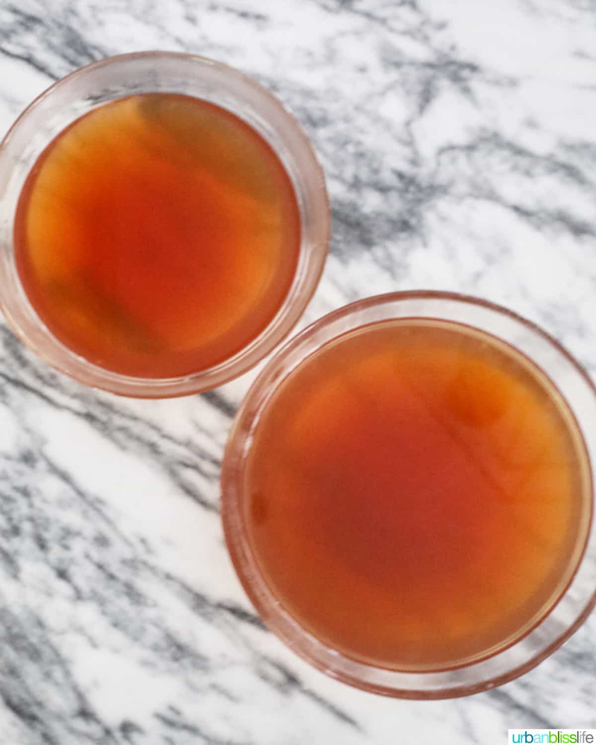 two bowls with crab stock on marble countertop.