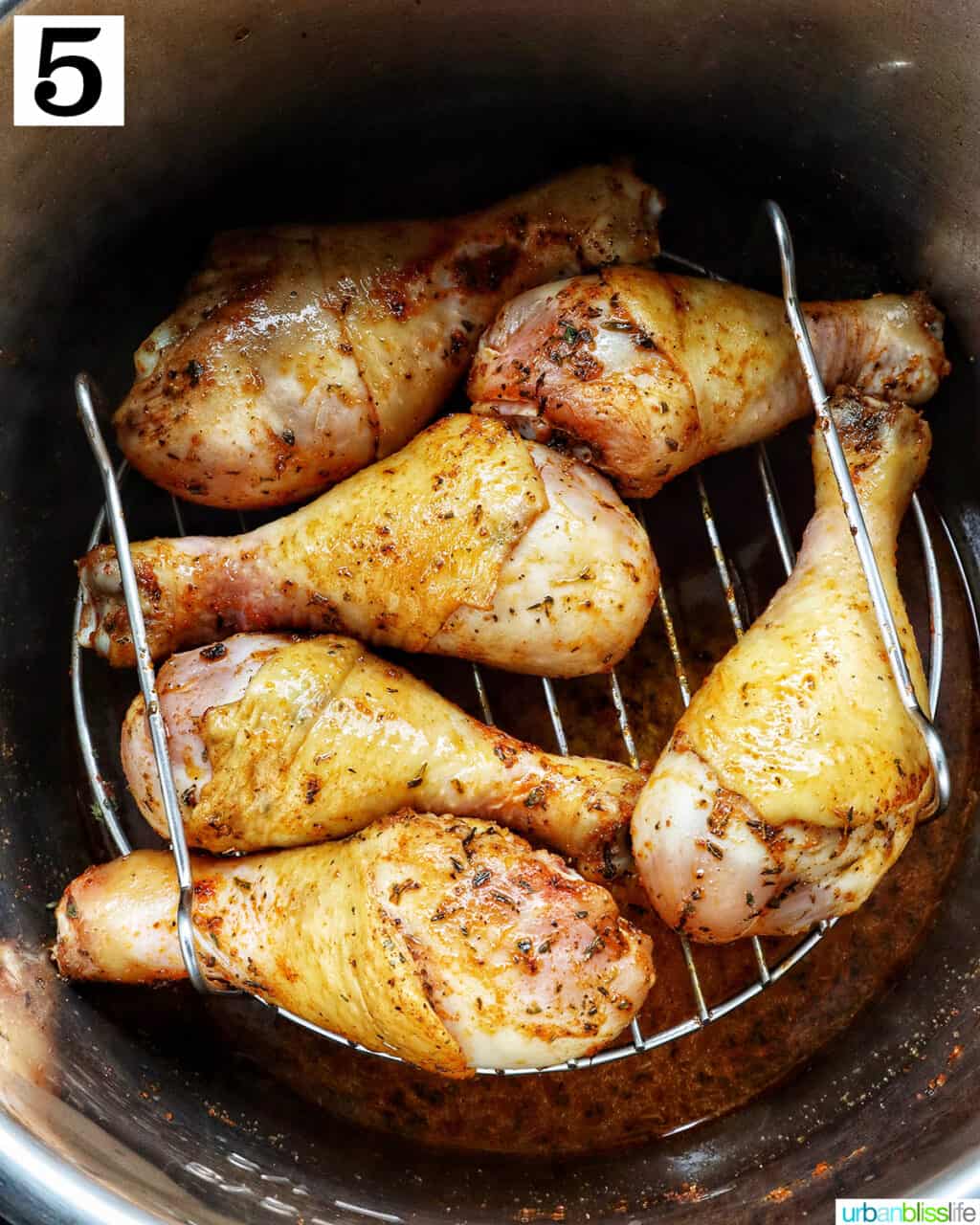 six  chicken drumsticks on a rack in an instant pot.
