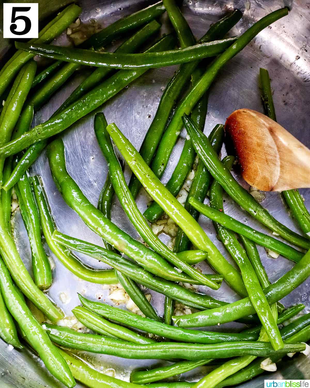 green beans in an Instant Pot with a wooden spoon.