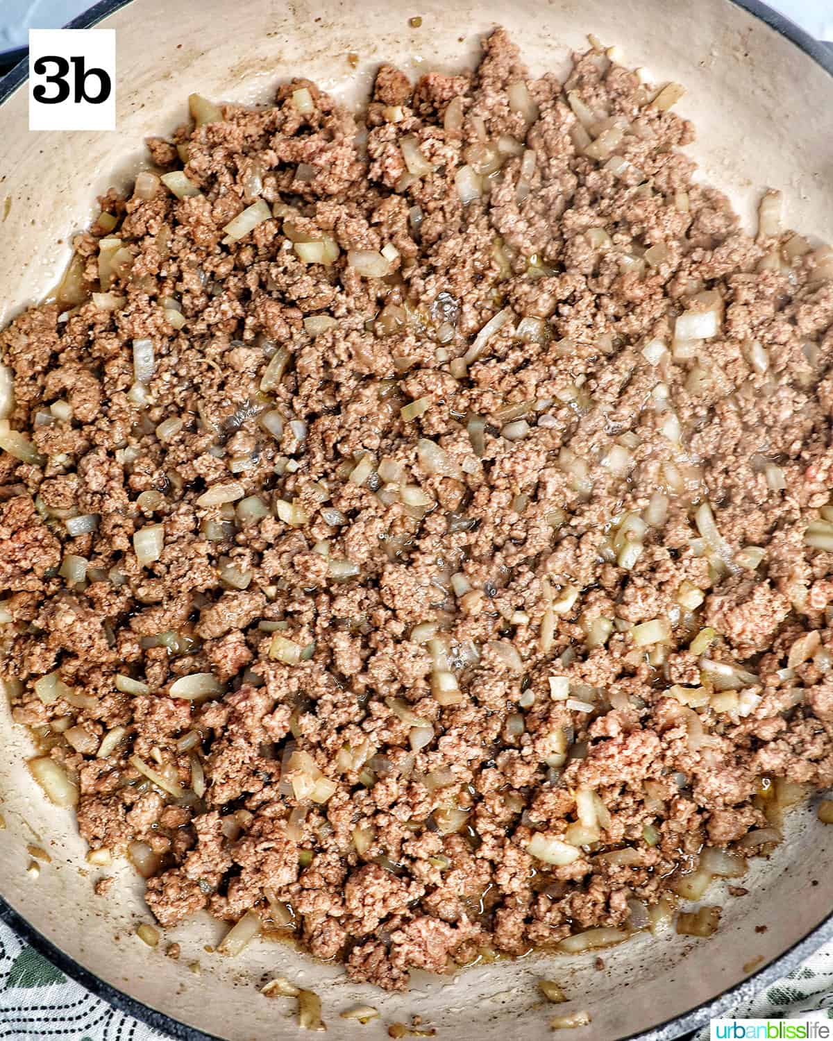 ground beef cooked with onions and garlic in a pan.