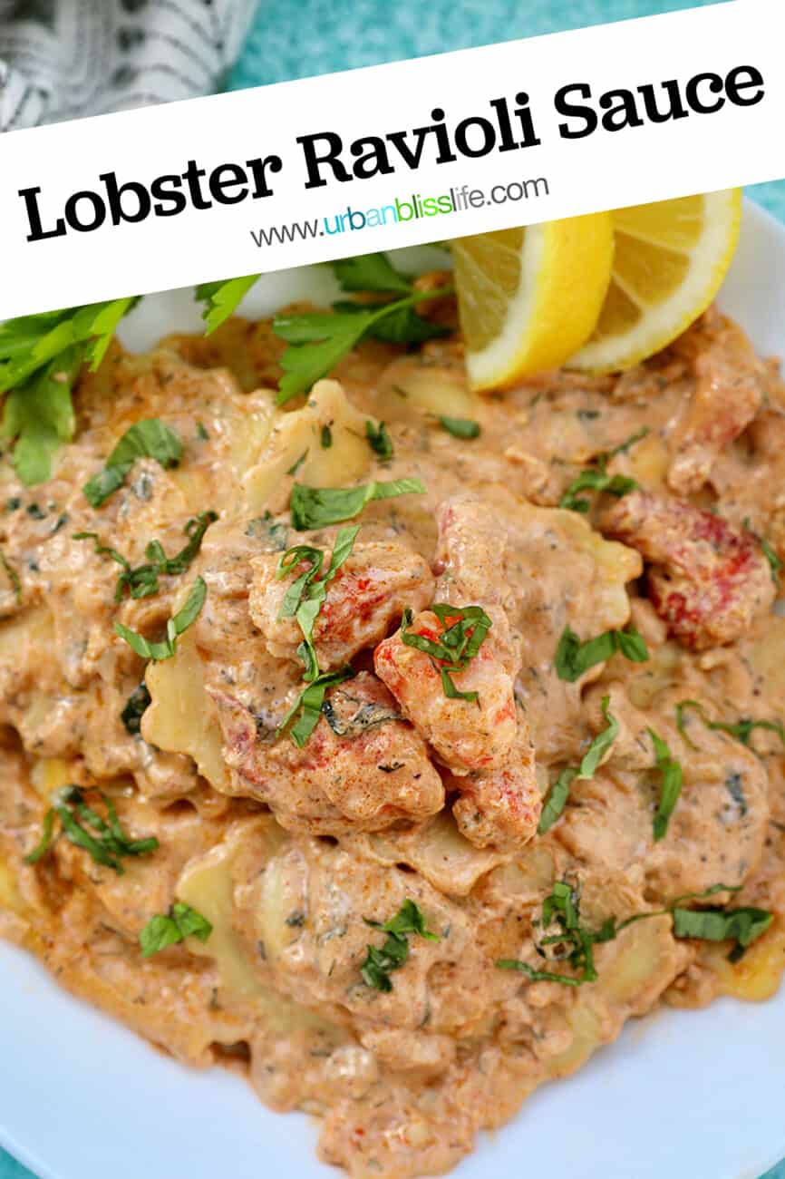 lobster ravioli sauce with lobster meat, lemon wedges, and herbs in a white bowl.
