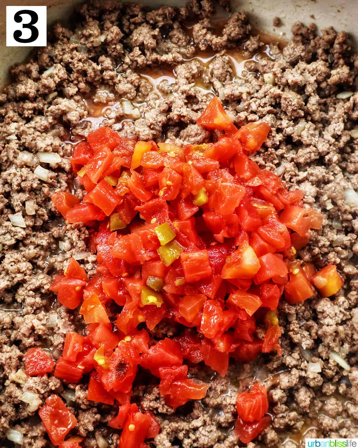 rotel tomatoes added to ground beef in a pan.