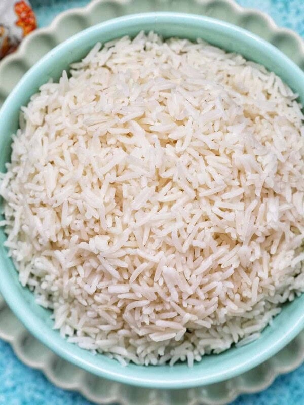 white basmati rice in a blue bowl on green plate.