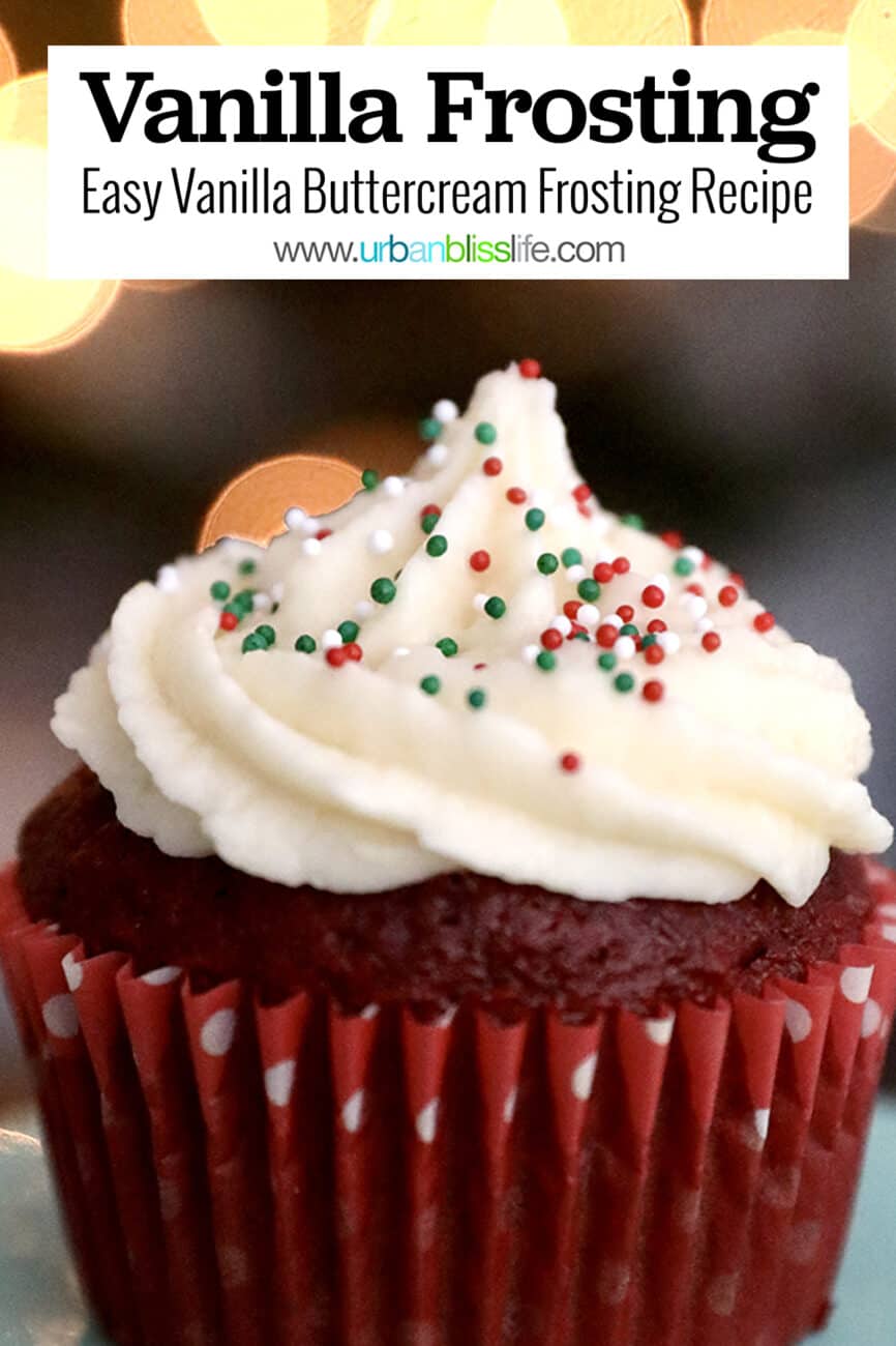 vanilla buttercream frosting on a red velvet cupcake with bokeh twinkle lights in the background.
