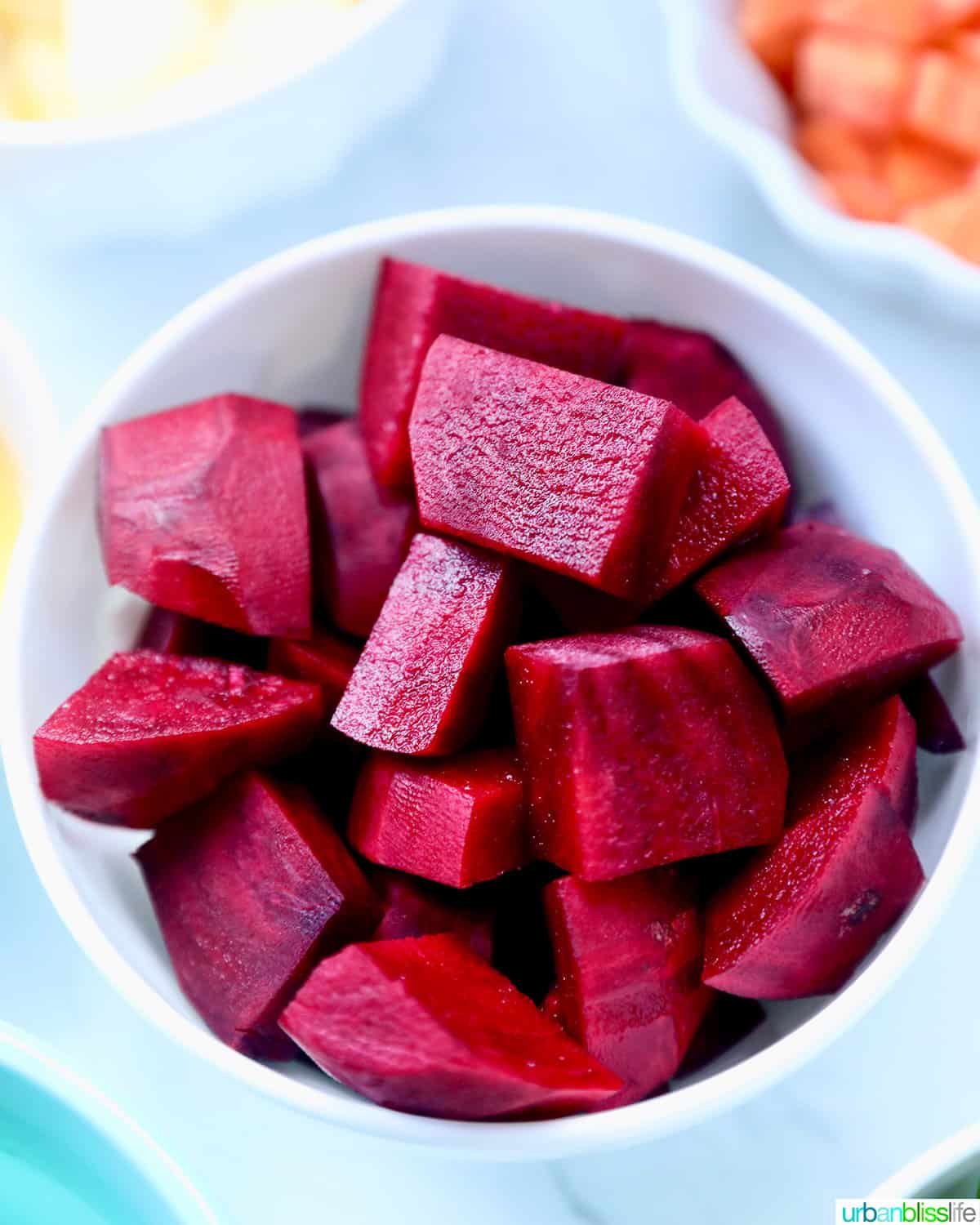 chopped red beets in a white bowl.