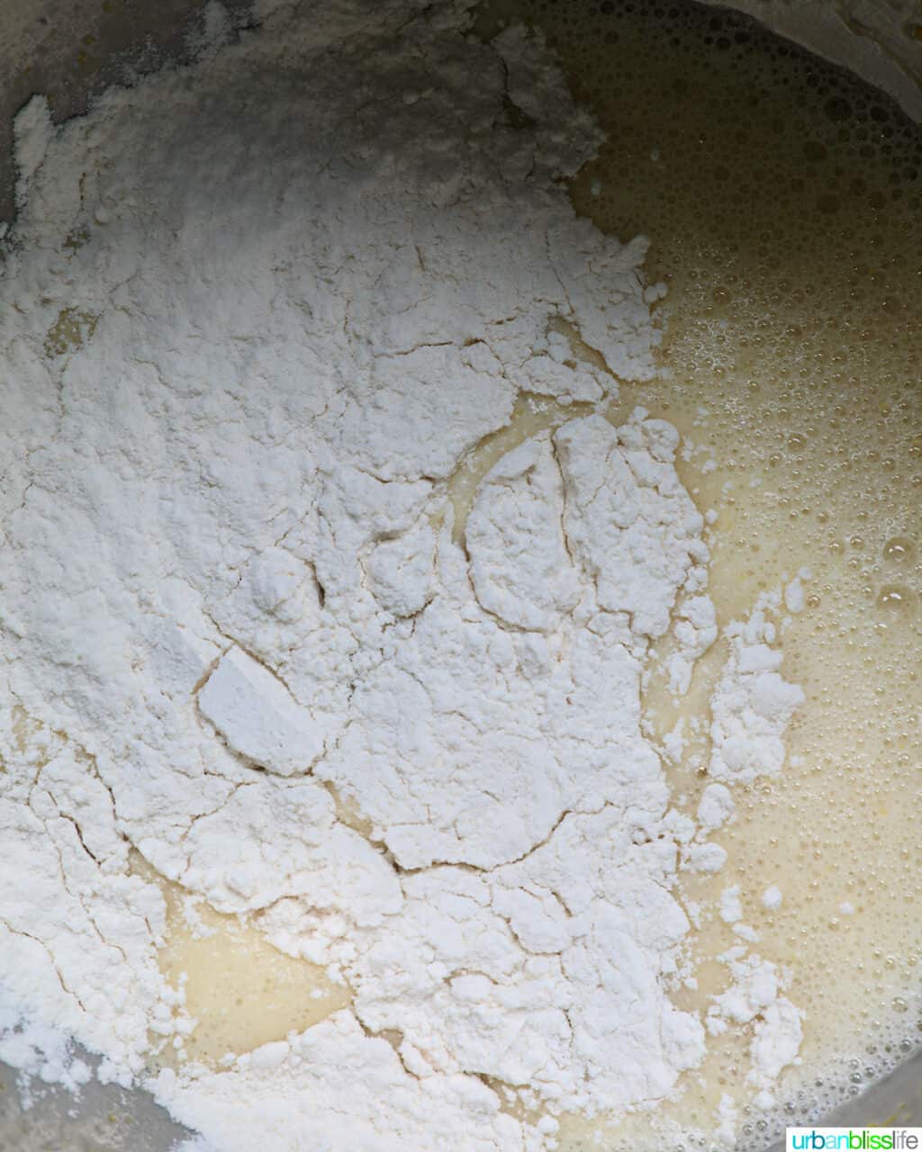 adding flour to wet ingredients to make muffins.