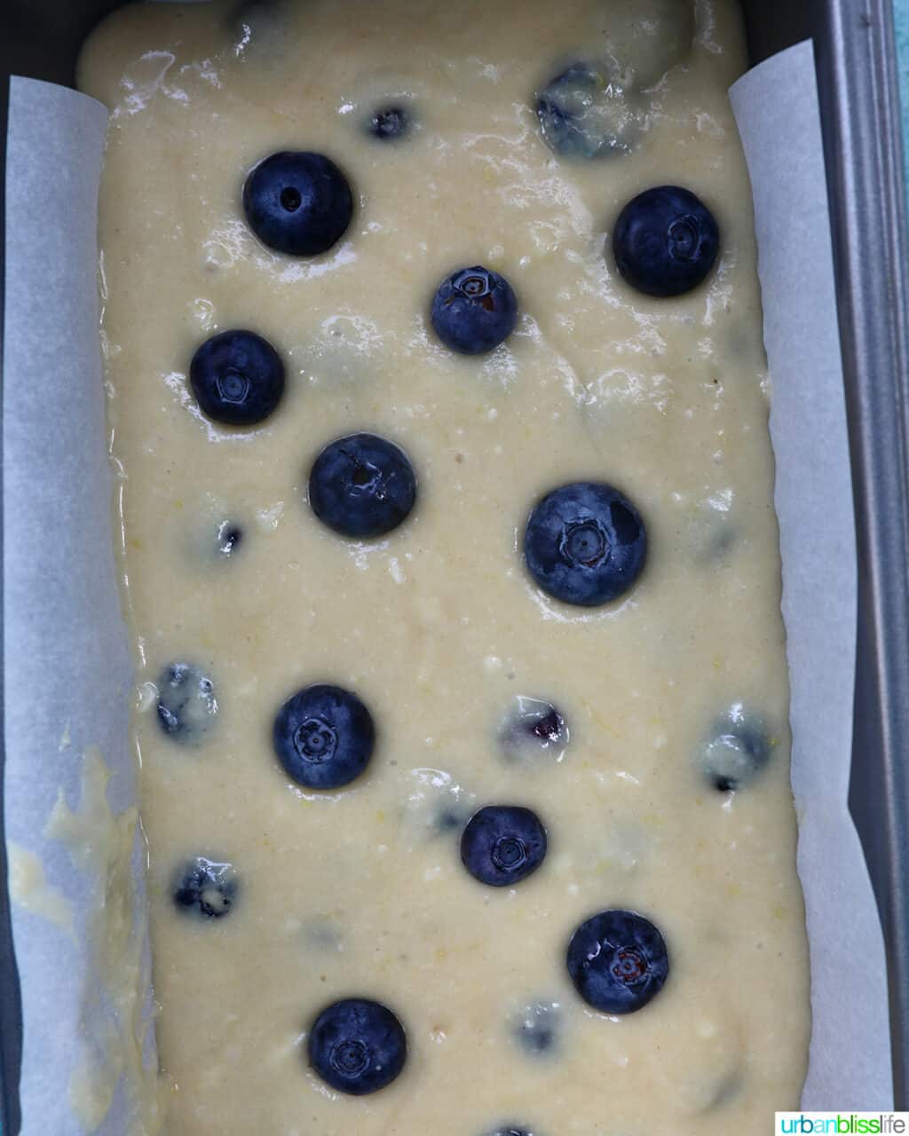 lemon blueberry pound cake batter in a parchment paper-lined loaf pan.