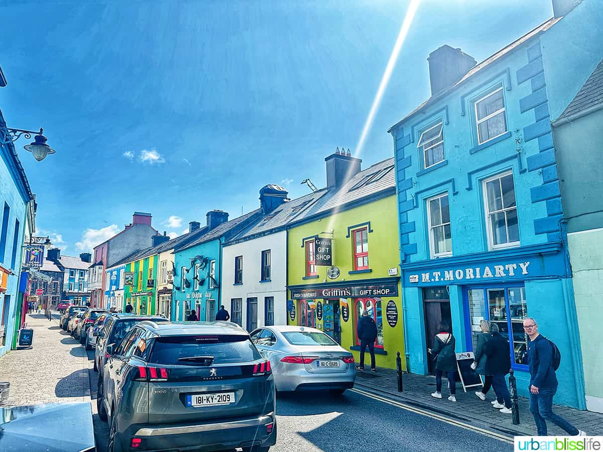 colorful street in dingle, ireland with cars