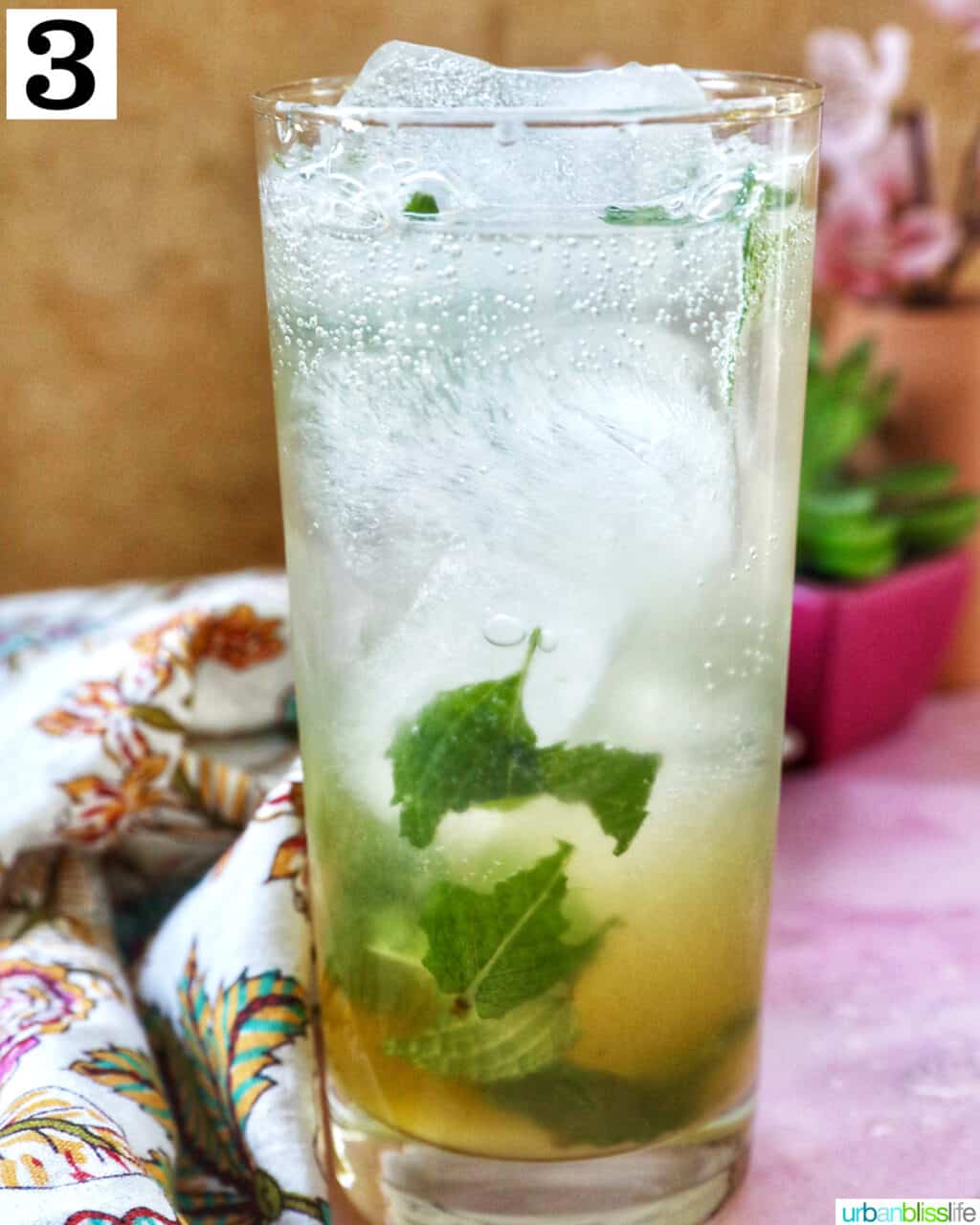 Mango mojito with mint leaves, ice cubes, and a lime slice garnish.