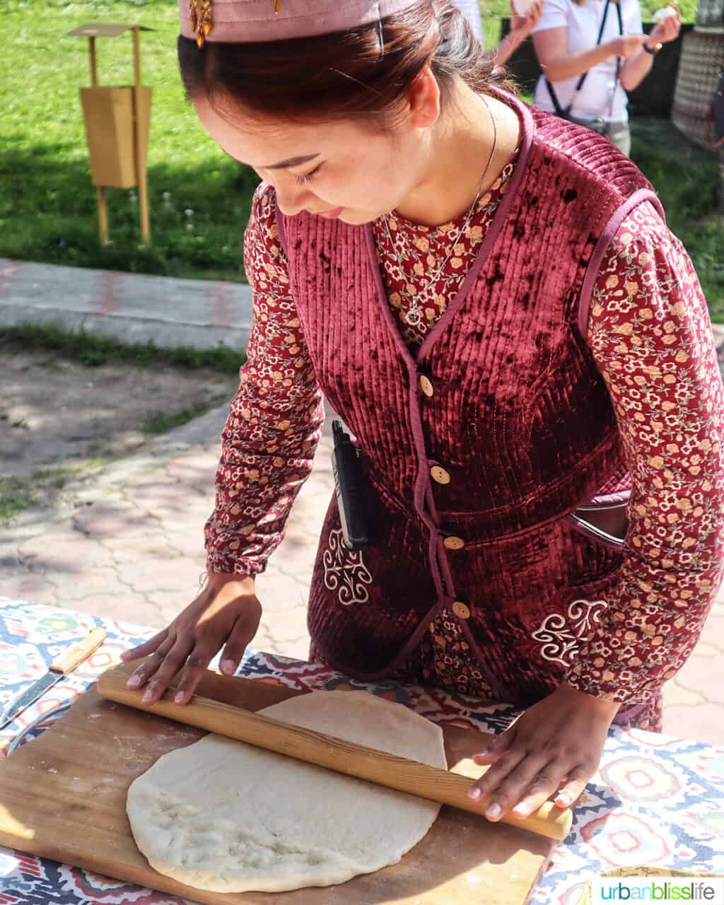 Woman rolling out dough to make baursak at Ethno Village of the Huns near Almaty, Kazakhstan.