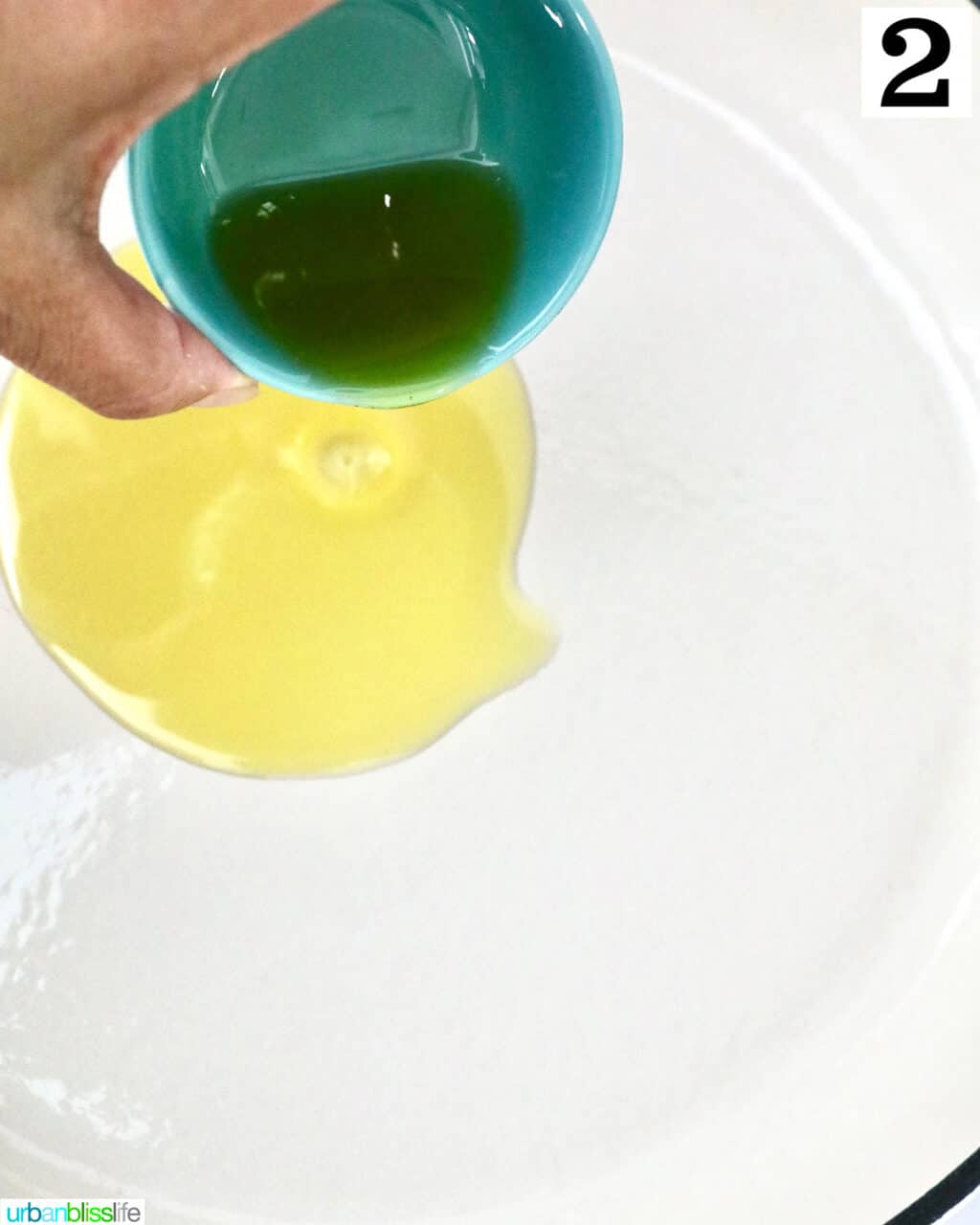 hand pouring olive oil into a pan.