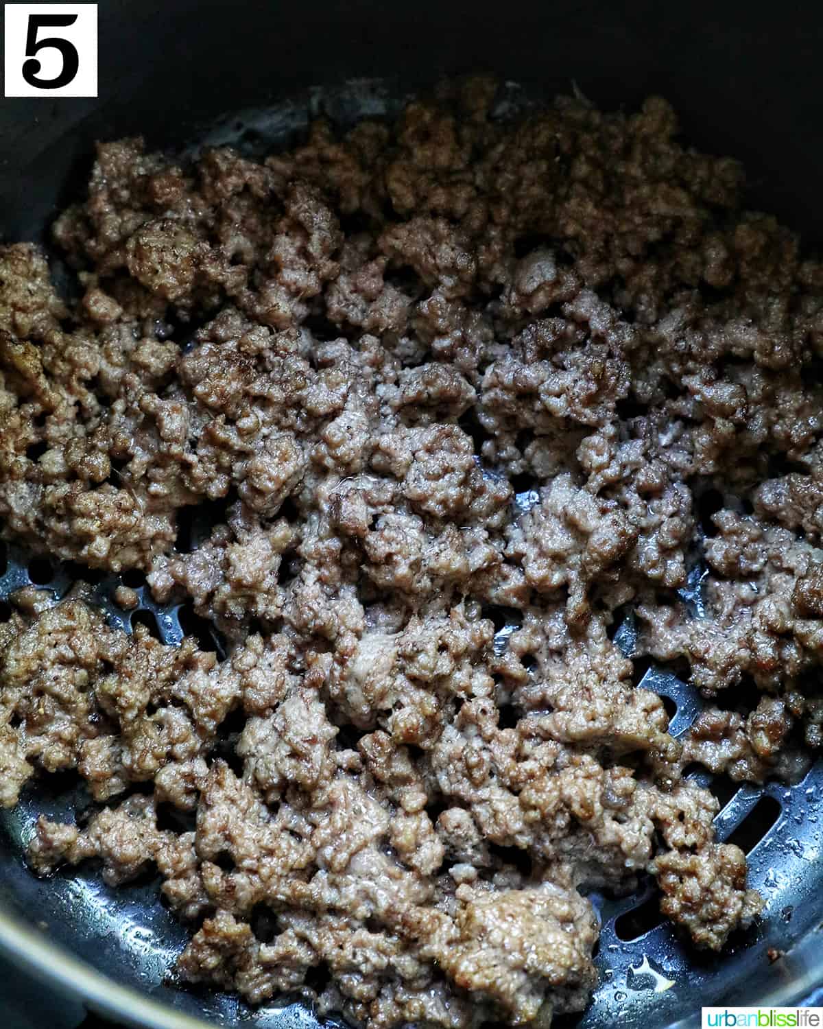 ground beef cooked in an air fryer basket.